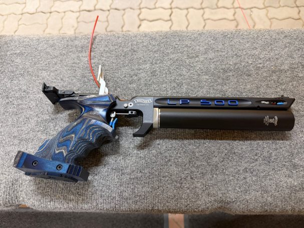 Schwarze und blaue Spritzpistole mit einem großen Silencer.
